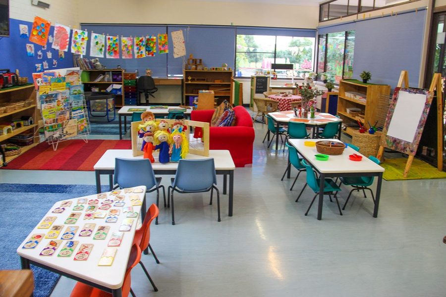The Koalas classroom with hanging children's artwork, puzzles, dress-up area and reading corner